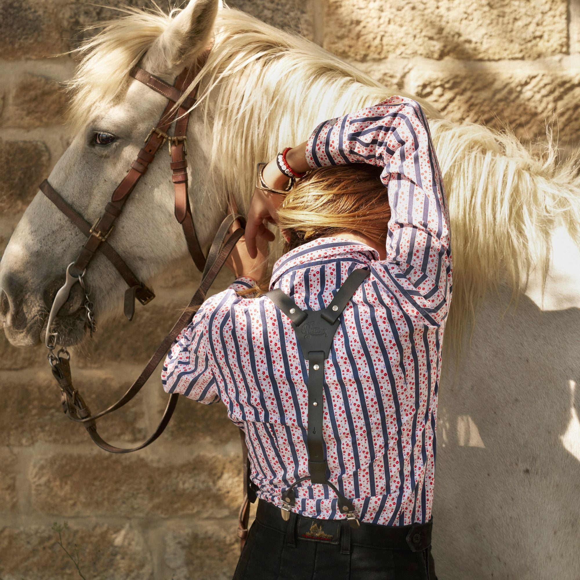 Woman wearing the Wiseguy Original Italian Job Suspenders, she is standing in front of a horse